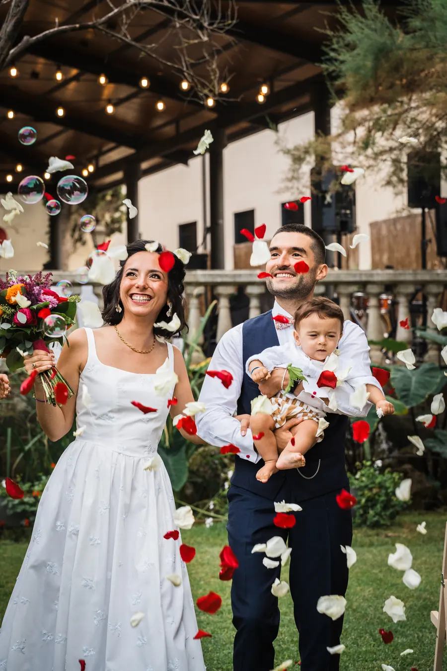 A couple leaves the ceremony under petals