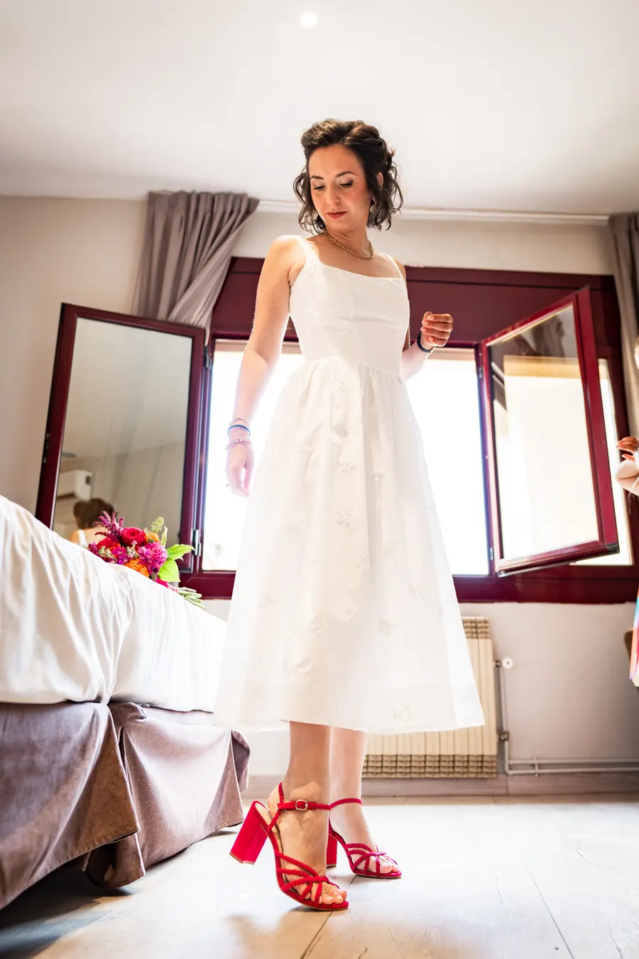 The bride in her room, red shoes on, ready